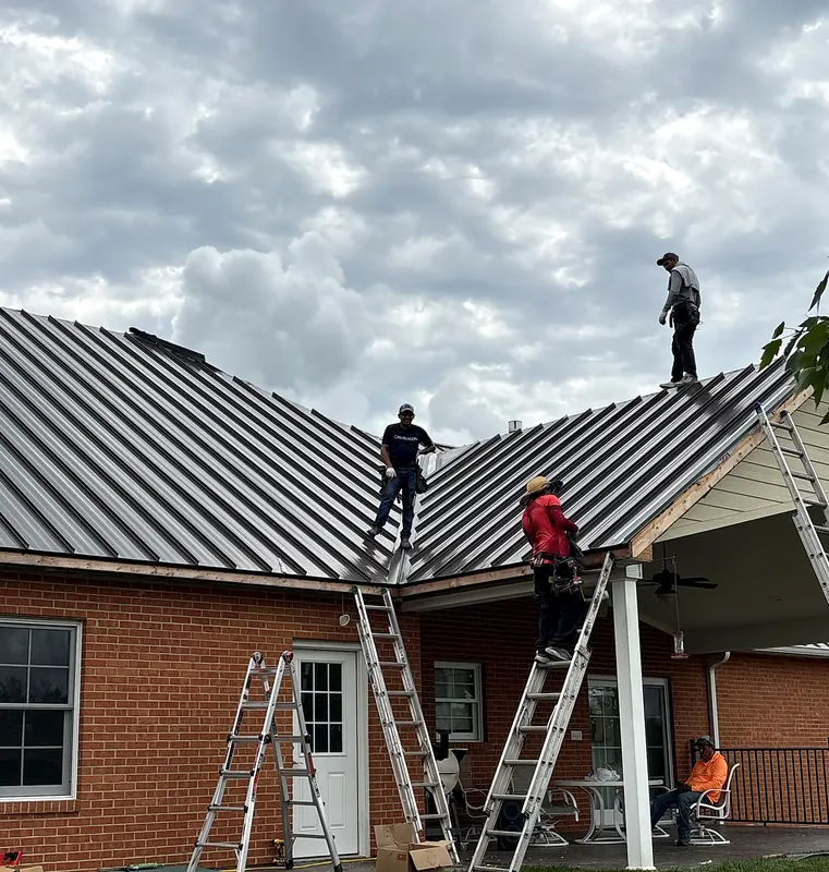 Prime Time Exteriors crew installing a standing seam metal roof on a brick home