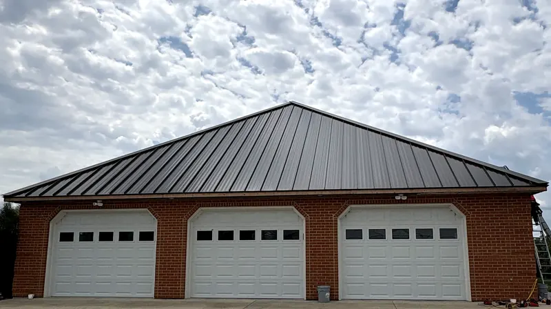 New dark bronze standing seam metal roof on a brick three-car garage