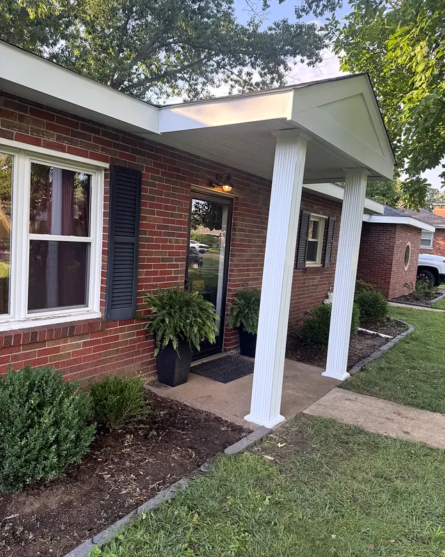 New front porch roof with white fluted columns on a brick ranch home